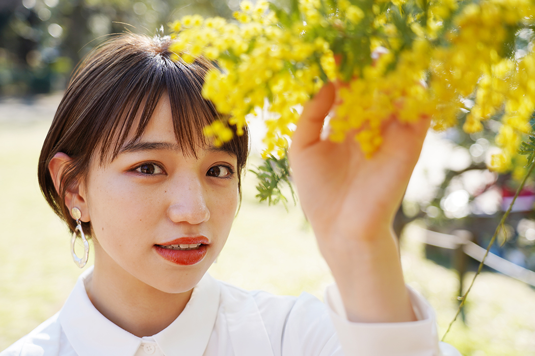 彼女が主役に、手で触れている花が脇役の写真になります。
